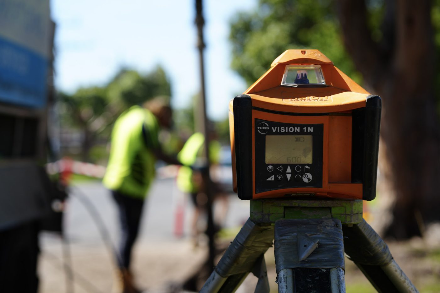Rotating laser level on a tripod being used to set drainage grades on site.